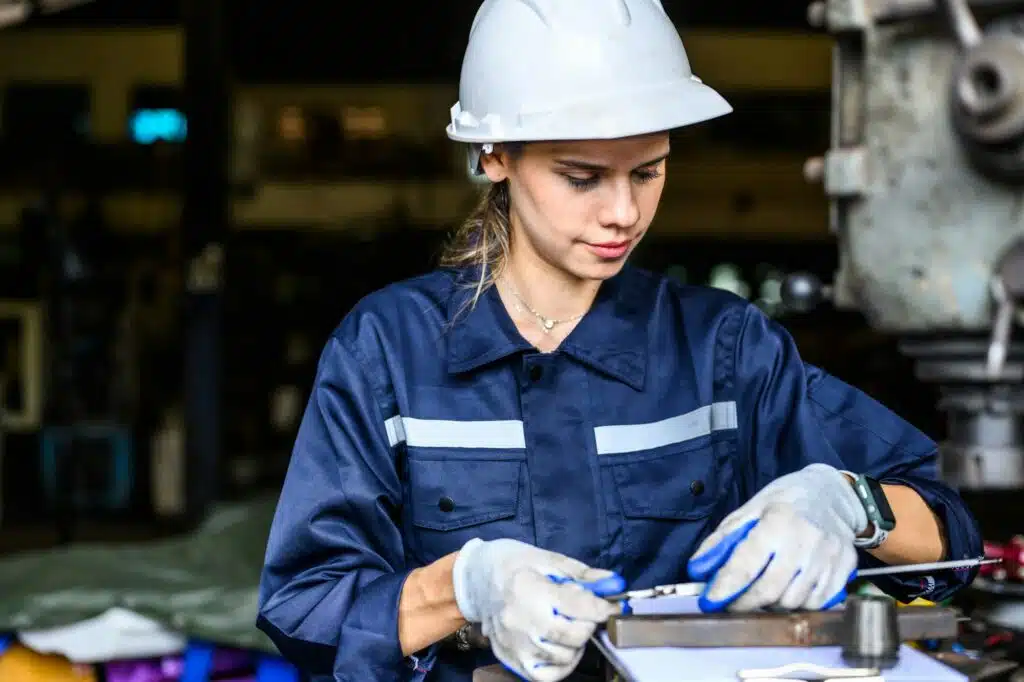 Junge Maschinenbauingenieurin bei der Reparatur einer Motormaschine in einer Werkstatt